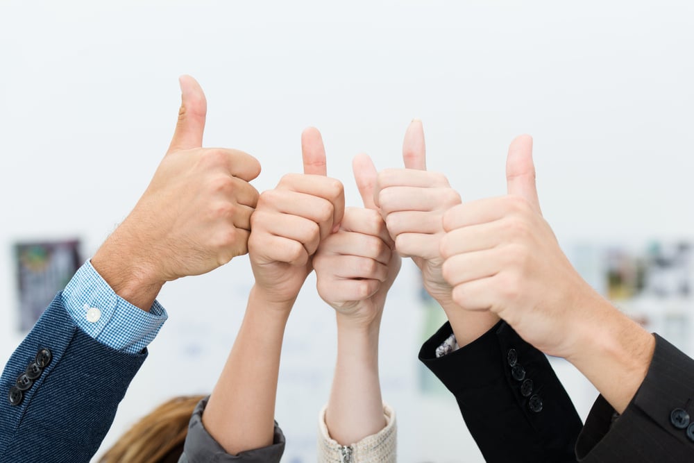 Successful diverse young business team giving a victorious thumbs up to show their success and motivation, close up view of their raised hands Successful diverse young business team giving a victorious thumbs up to show their success and motivation, close up view of their raised hands